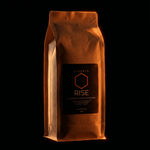 VIGORYS RISE Mushroom Coffee Blend 16oz kraft bag with warm orange glow on black background - Lion's Mane and Chaga mushroom infused coffee for cognitive clarity and jitter-free energy, CORE Protocol designation