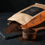 VIGORYS RISE Mushroom Coffee Blend bag with fresh ground coffee spilling onto slate surface and wooden scoop, showing Lion's Mane and Chaga infused coffee grounds texture.